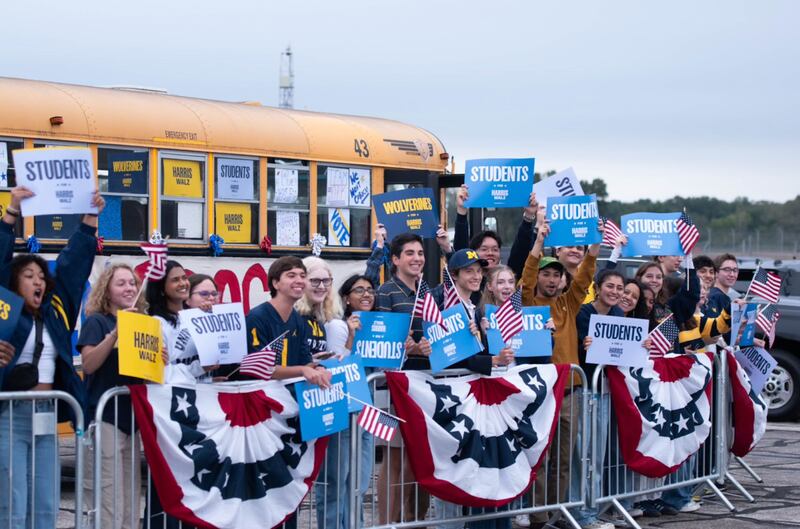 University of Michigan students waving signs in support of Walz.