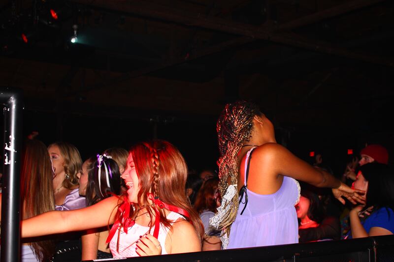Two fans with bows in their hair dance along to the music.
