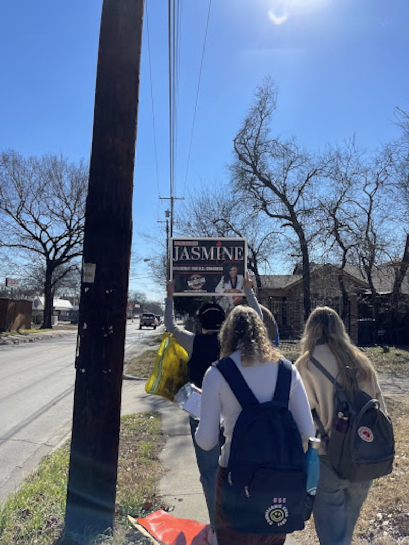 A photo of students walking in protest with a student holding up a sign.