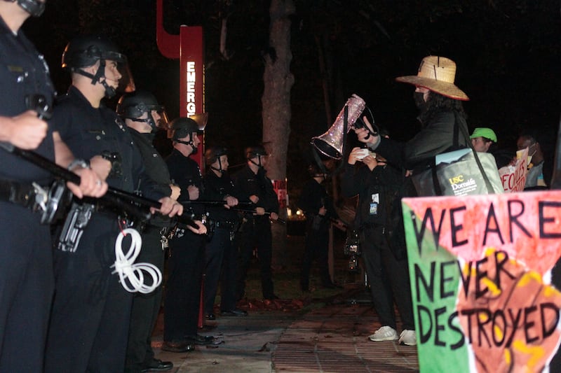 Photo of law enforcement and protestors standing face to face.