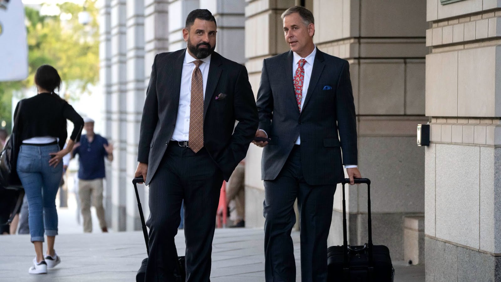 Photo of two men walking in suits.