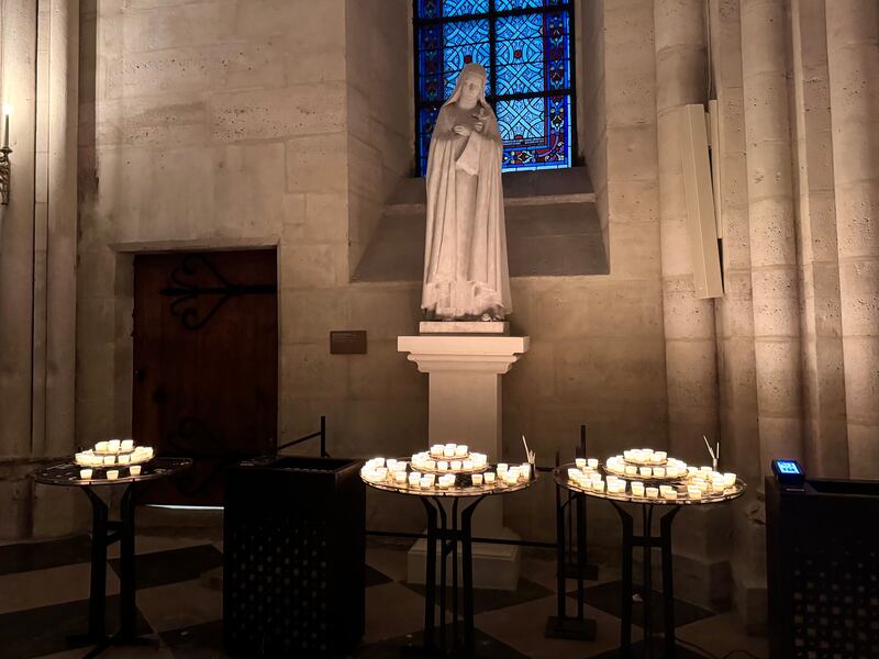 Candle stands lined the entrance and side aisles of Notre-Dame Cathedral, where visitors lit and placed dozens of candles during Monday night’s vigil (Photo by Charlotte Calmès)