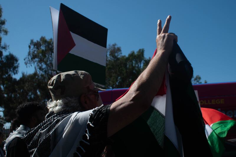 A protester holds a Palestinian Flag as he marches with other pro-Palestinian supporters.