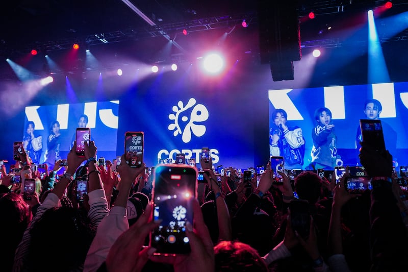 Fans raise their phones filming a concert