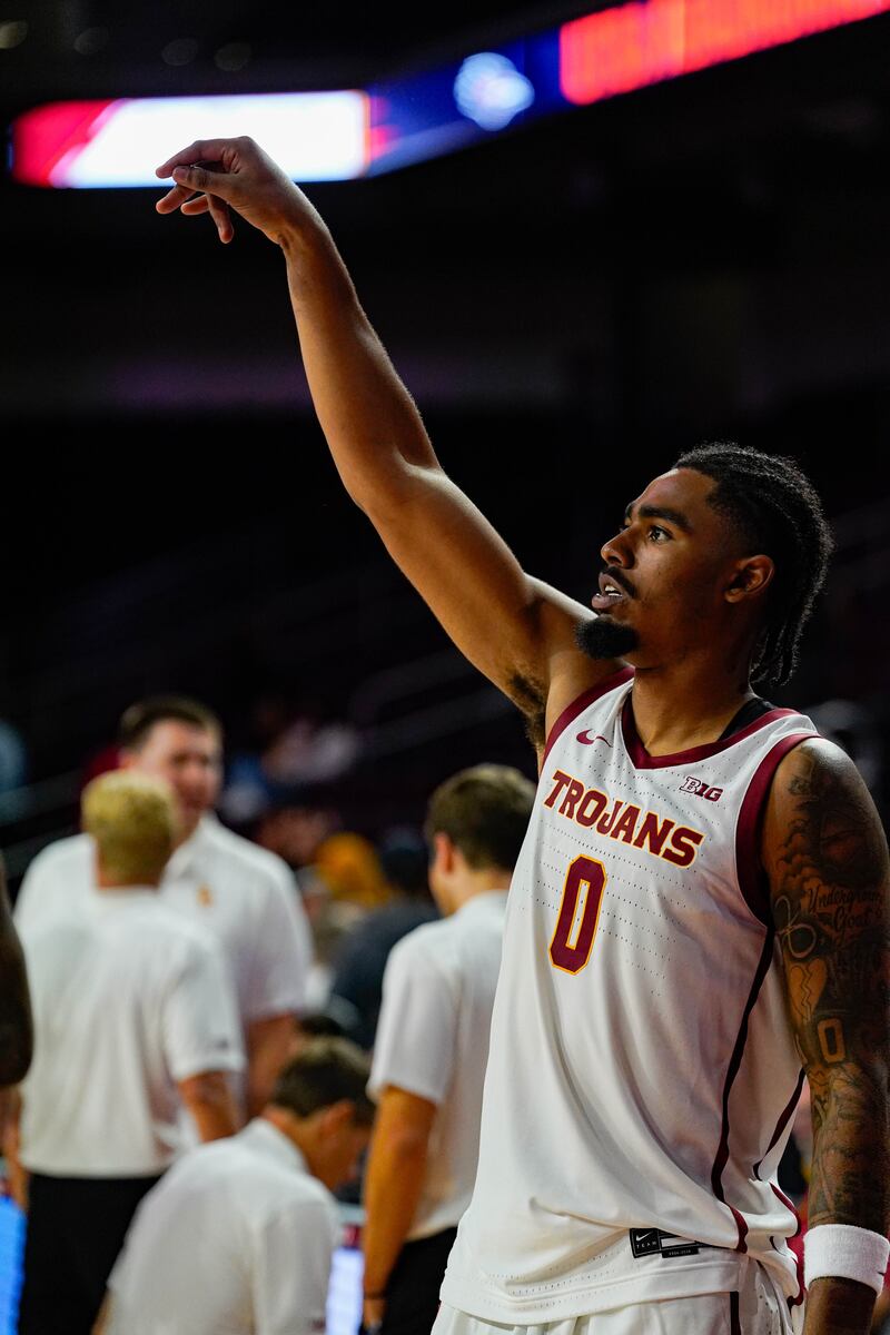 A basketball player warms up with a shot