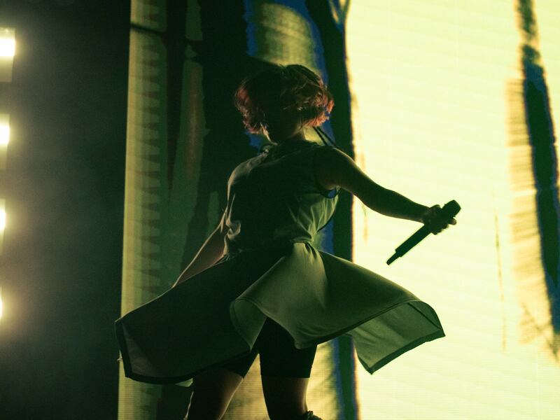 Photo of a woman dancing in front of a bright yellow screen