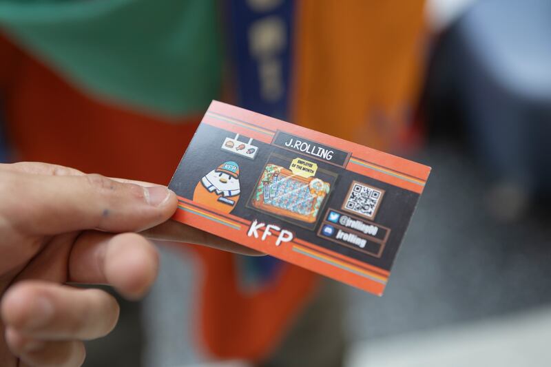 Photo of a hand holding a small card saying "KFP"