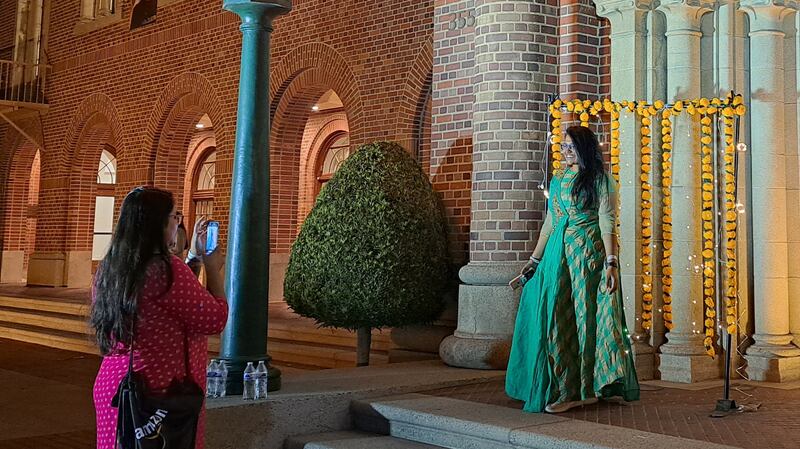 Students take photos by the entrance to the Bovard Auditorium, USC.