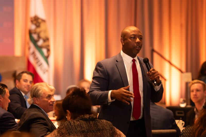 Tim Scott in the middle of the audience of the CAGOP giving a speech.