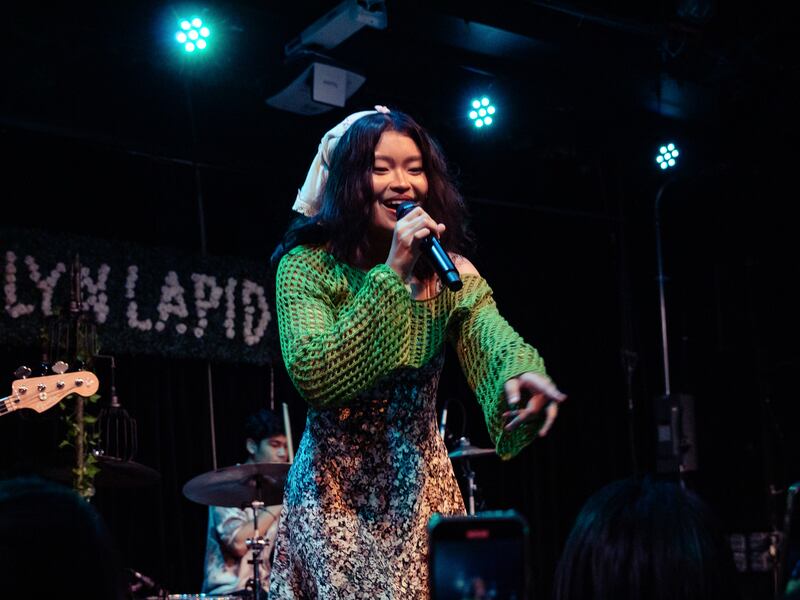 Photo of a singer in green pointing