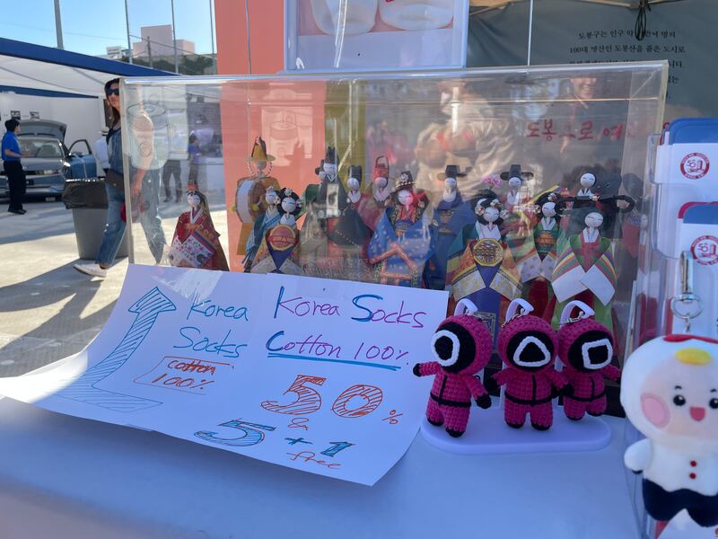 Photo of a glass case with many dolls next to various other dolls