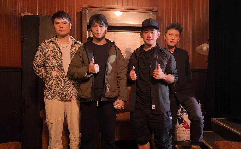 Photo of four men standing together with thumbs up