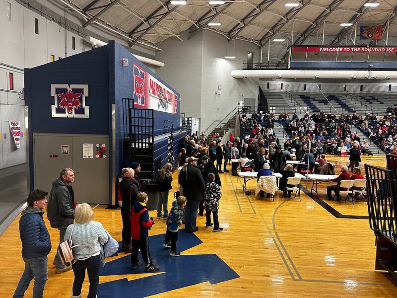 Photo of people lined up in a high school gym.