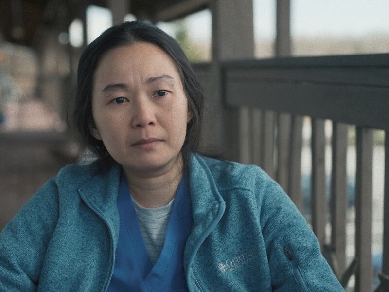 Film screenshot of a woman in a nurse uniform on a porch