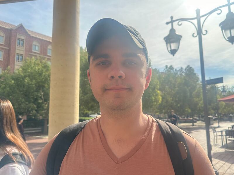 A man wearing a hat and light colored shirt.