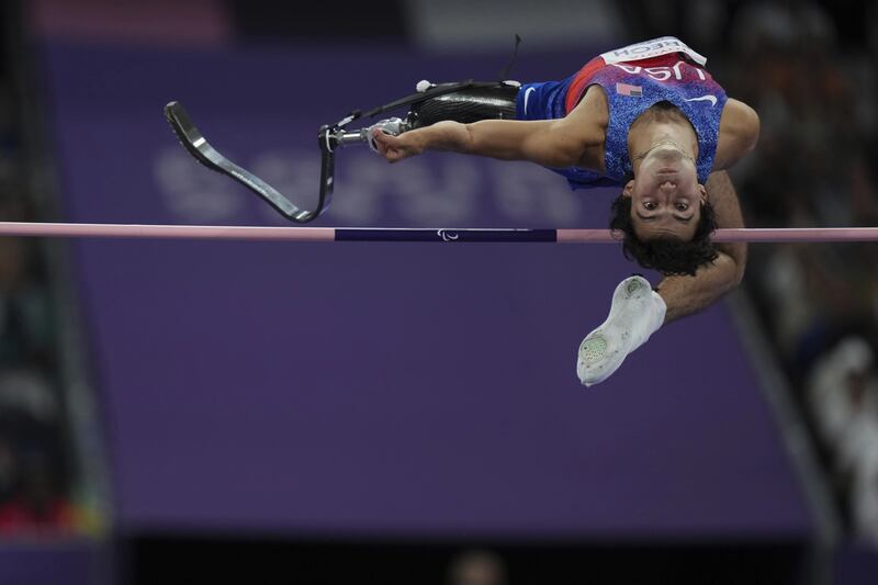 Photo of a man jumping over a horizontal bar.