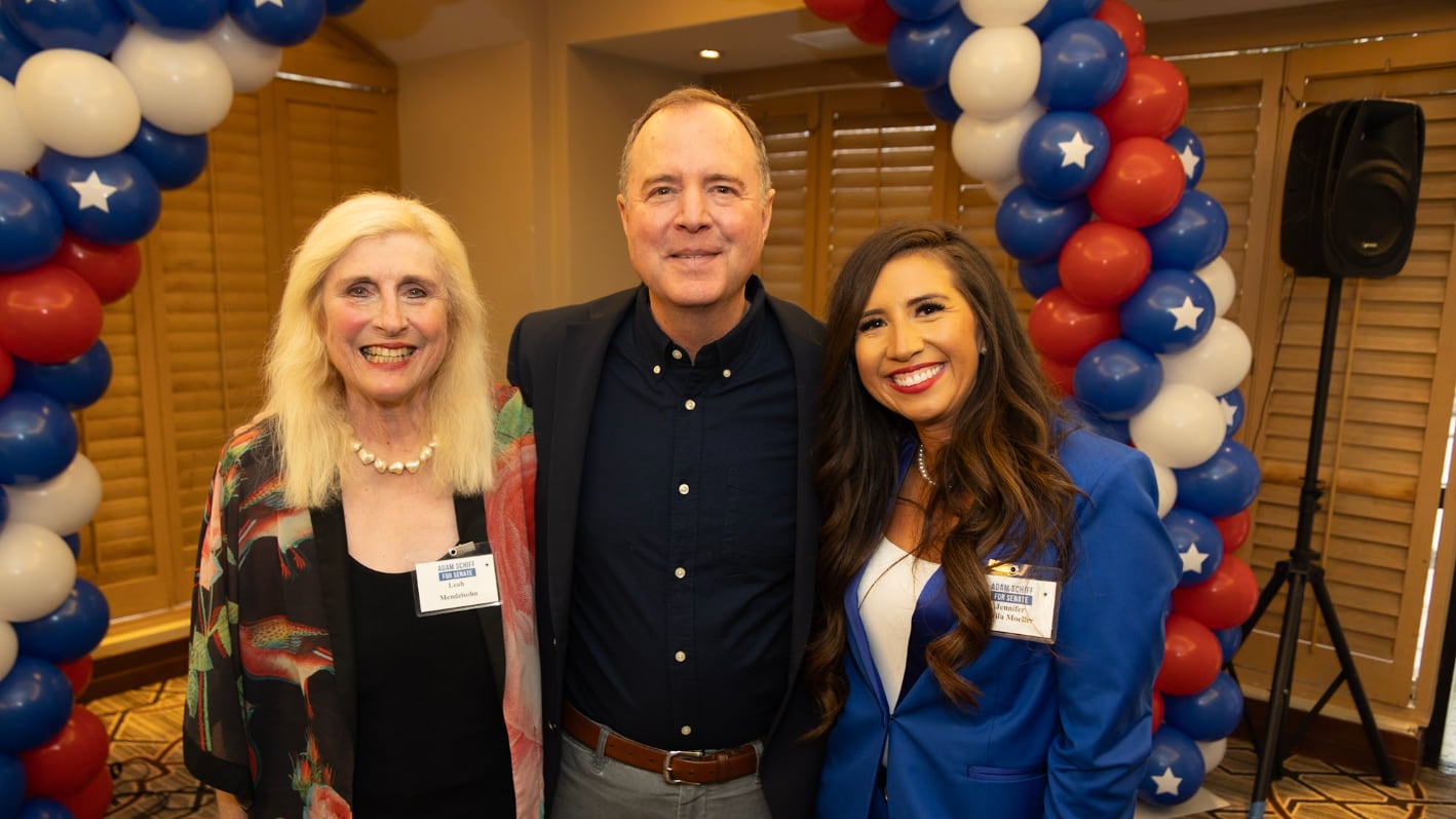 Three individuals posing in front of balloons at a campaign event, including Schiff and Mendelsohn.