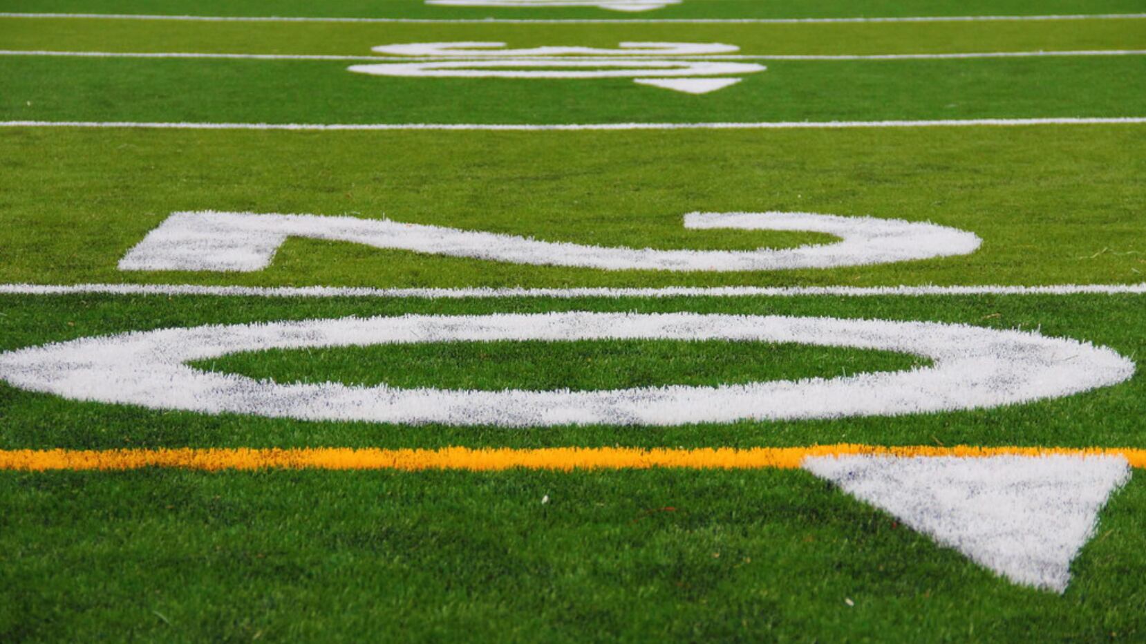 A close-up of yard markers on a football field.
