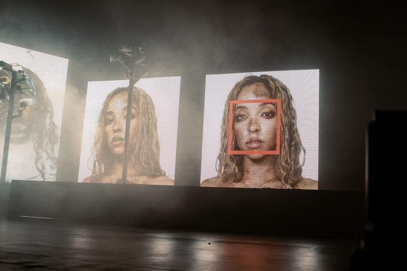 Photo of screens displaying a woman's headshot with a red square over one image's face