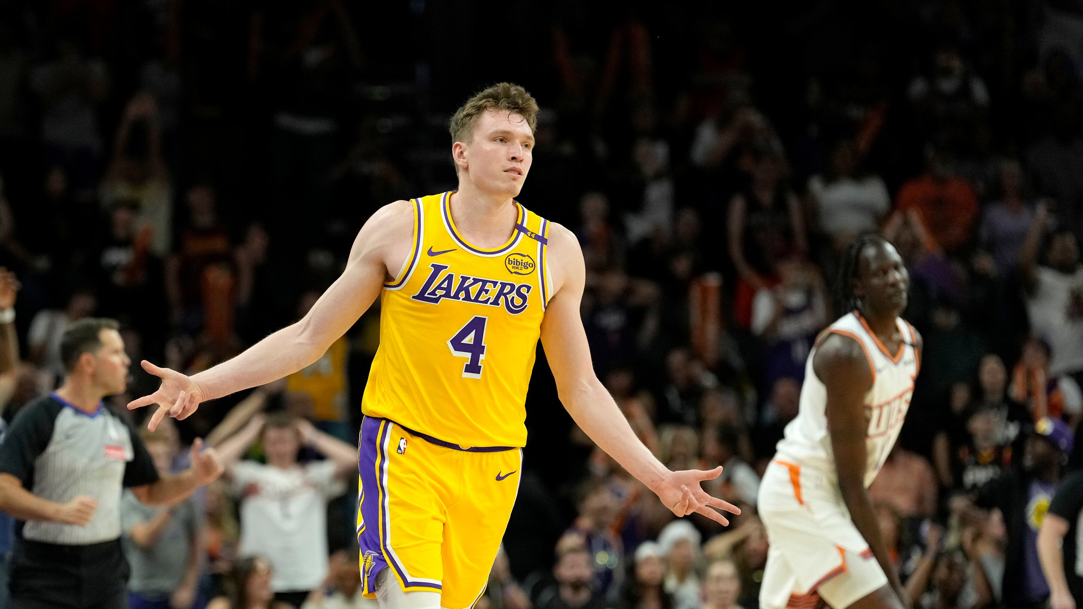 Los Angeles Lakers guard Dalton Knecht celebrates his 3-pointer as Phoenix Suns center Bol Bol, right, looks on during the second half of an NBA preseason basketball game in Phoenix.