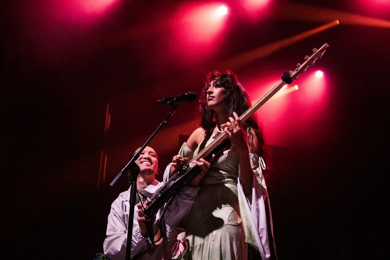 Photo of a woman with a guitar next to a man