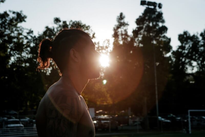 Sunlight peeks through the side of a player's face during tryouts held by the West Hollywood Soccer Club at Griffith Park in Los Angeles on Sunday, July 18, 2021.