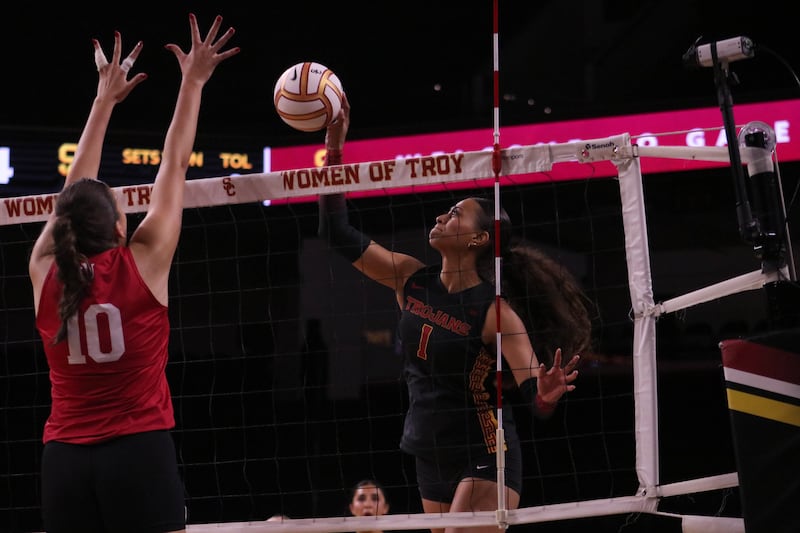 Faumuina (1) elevates over the net to deliver the ball over the outstretched arms of a Nebraska defender.