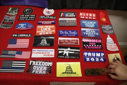 Stickers sit on the table and are being sold at the Trump HQ event.