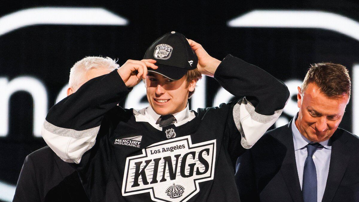 No. 26 overall pick Liam Greentree puts on his black Los Angeles Kings hat after being drafted by the organization. He is also wearing a black Kings jersey.