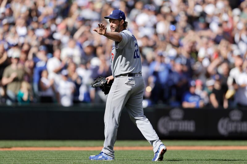Photo of a baseball player waving as he walks off the field.