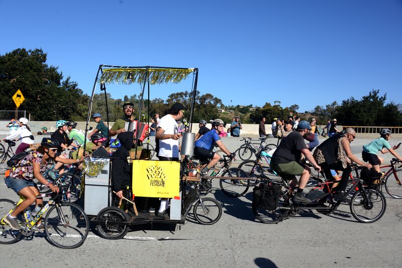 A crew of bikers haul a mobile stage and live musicians northbound on the 110 freeway during Arroyo Fest. (Photo by Jules Feeney)