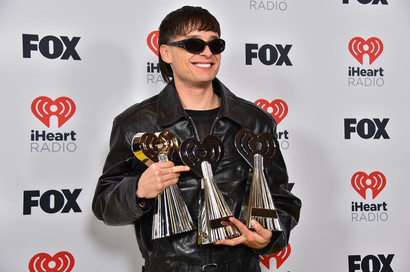 Photo of a musician posing with his awards.