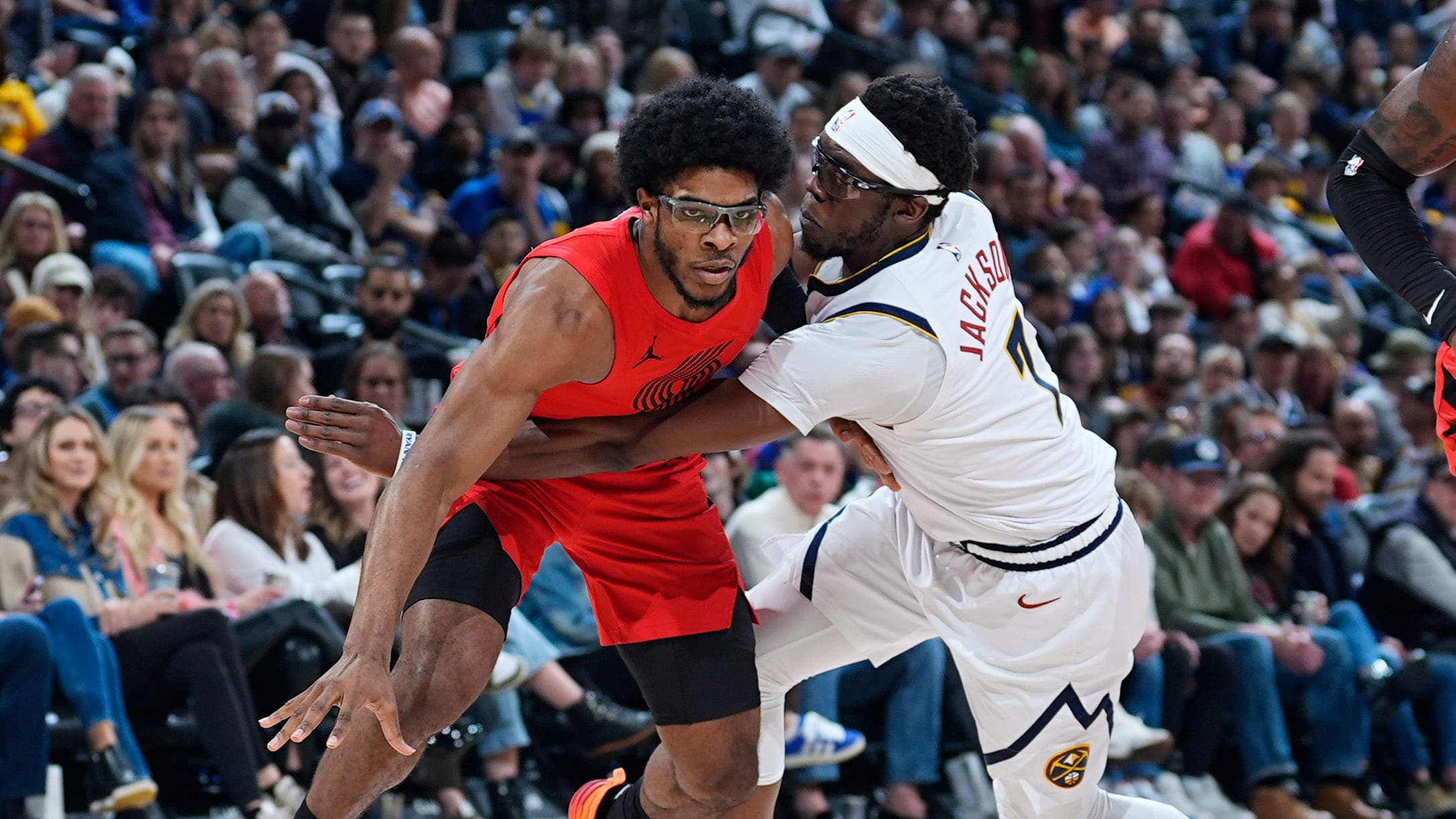 Portland Trail Blazers guard Scoot Henderson, wearing number 00 in Portland's red, Jordan brand jersey, pursues a loose ball as Denver Nuggets guard Reggie Jackson defends in the first half of an NBA basketball game Sunday, Feb. 4, 2024, in Denver. (AP/David Zalubowski)