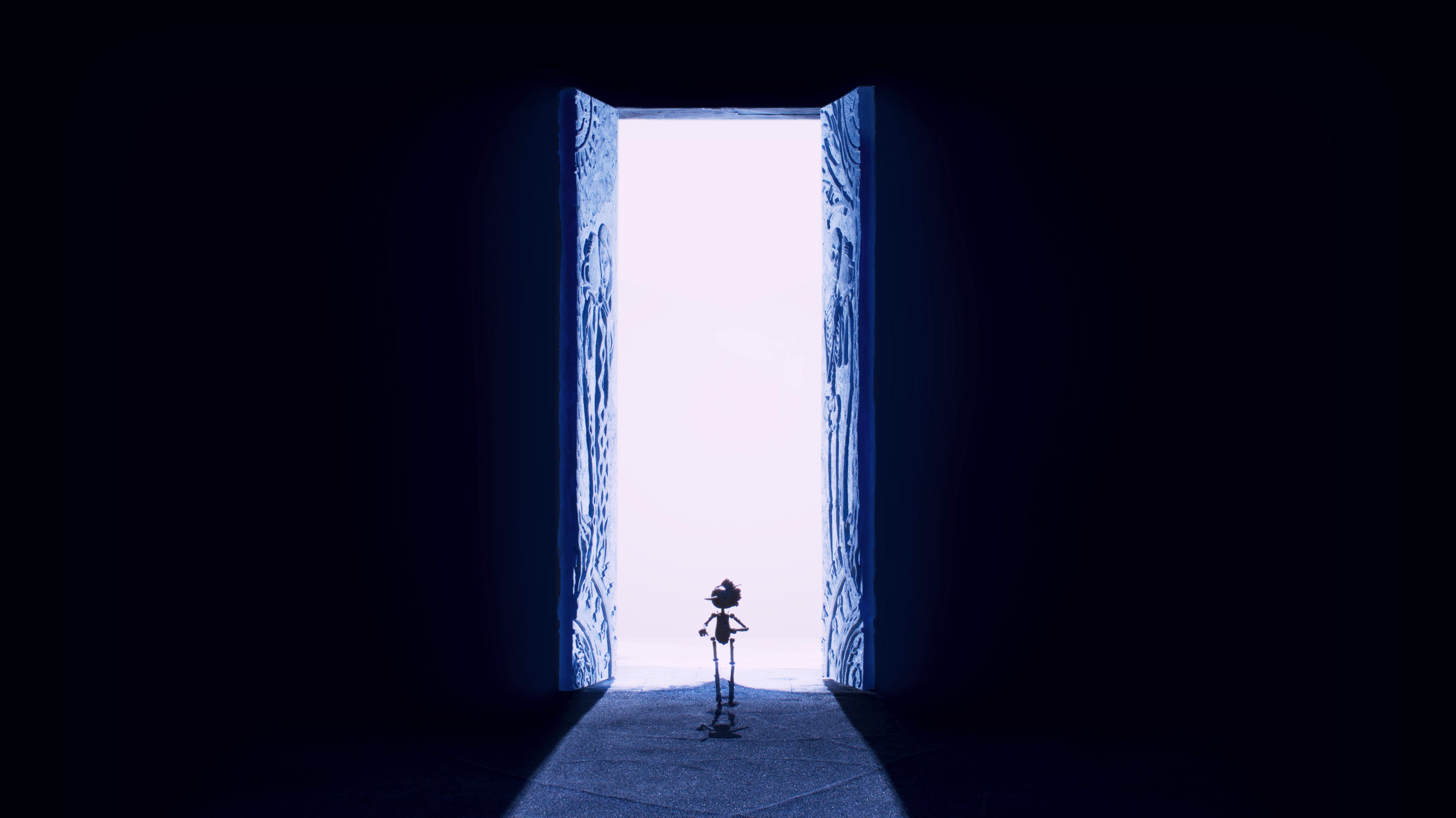 Film shot of a puppet standing before a large door with light shining through