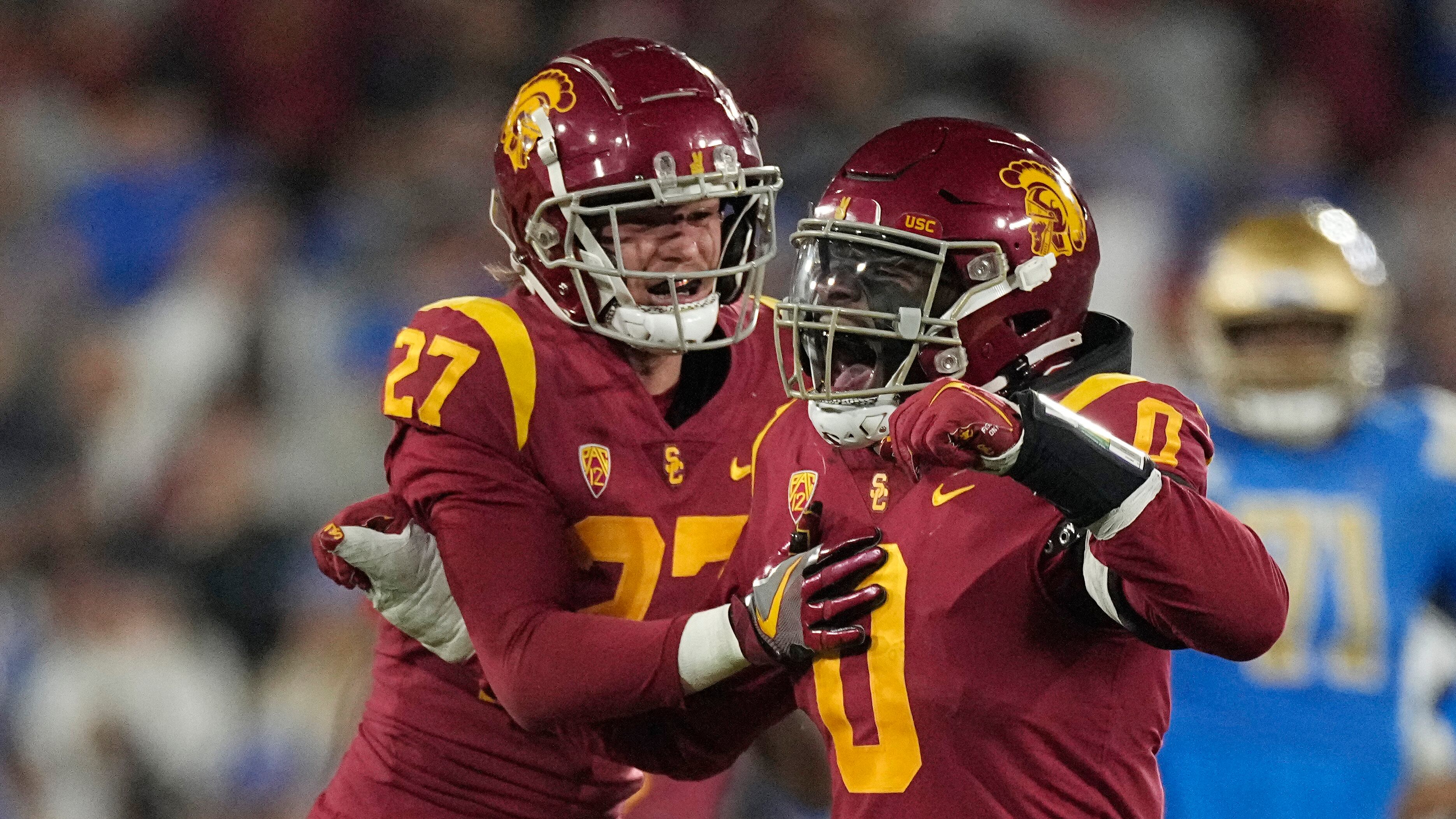 Defensive end Korey Foreman, wearing red, celebrates with defensive back Bryson Shaw after intercepting a pass during the second half of an NCAA college football game against UCLA.