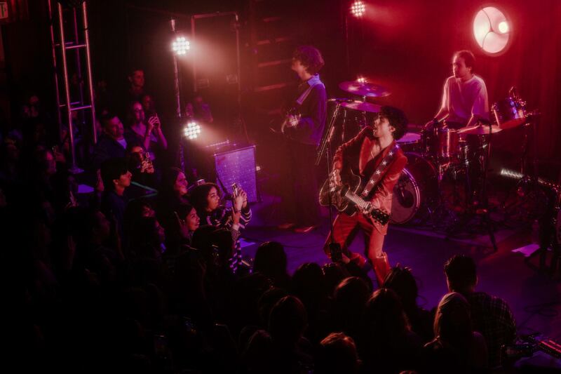 A photo of Sanchez and his band playing the guitar and singing onstage.