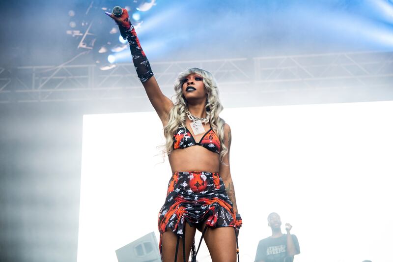 Photo of a woman holding a mic and performing on stage.