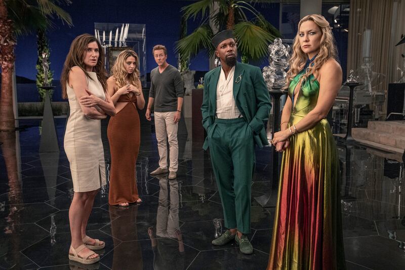 A photo from the film of the actors standing and staring at an offscreen character with confused looks on their faces.