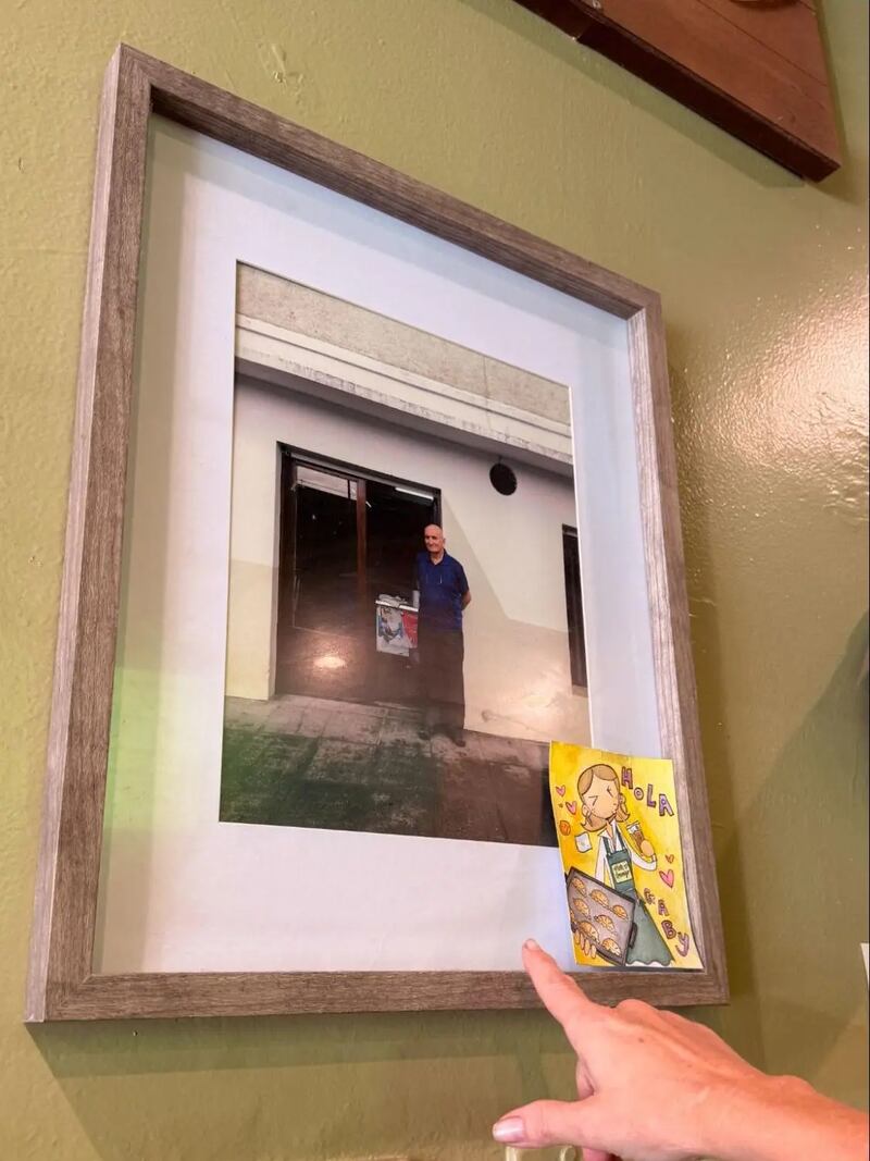 Photo of framed photograph with someone pointing to it.