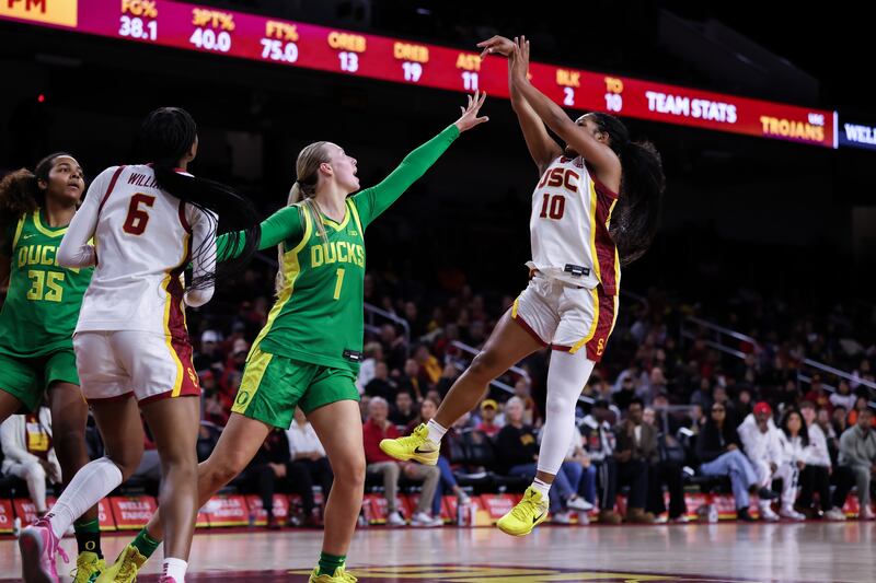 Malia Samuels (10) takes a jump shot over the outstretched hand of an Oregon defender.