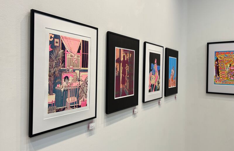 Photo of four framed artworks with vibrant colors and black and white frames