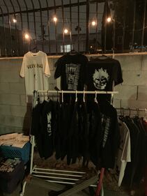 Photo of vending booth with clothing on racks.