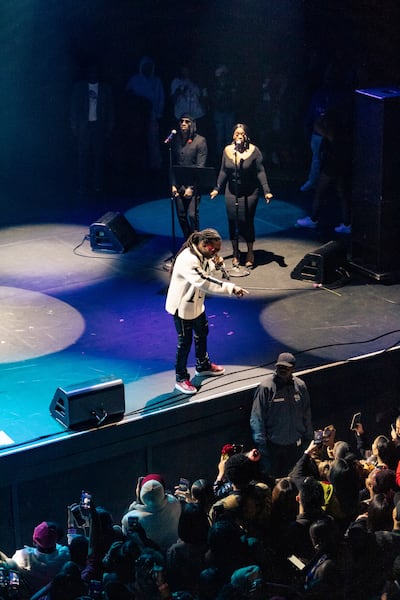 A photo of Jacquees on stage pointing to a fan in the audience.