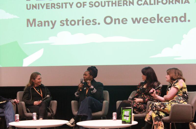 Dana is holding a microphone and speaking with her hand in a fist. There is one panelist to the left of her and two to the right.