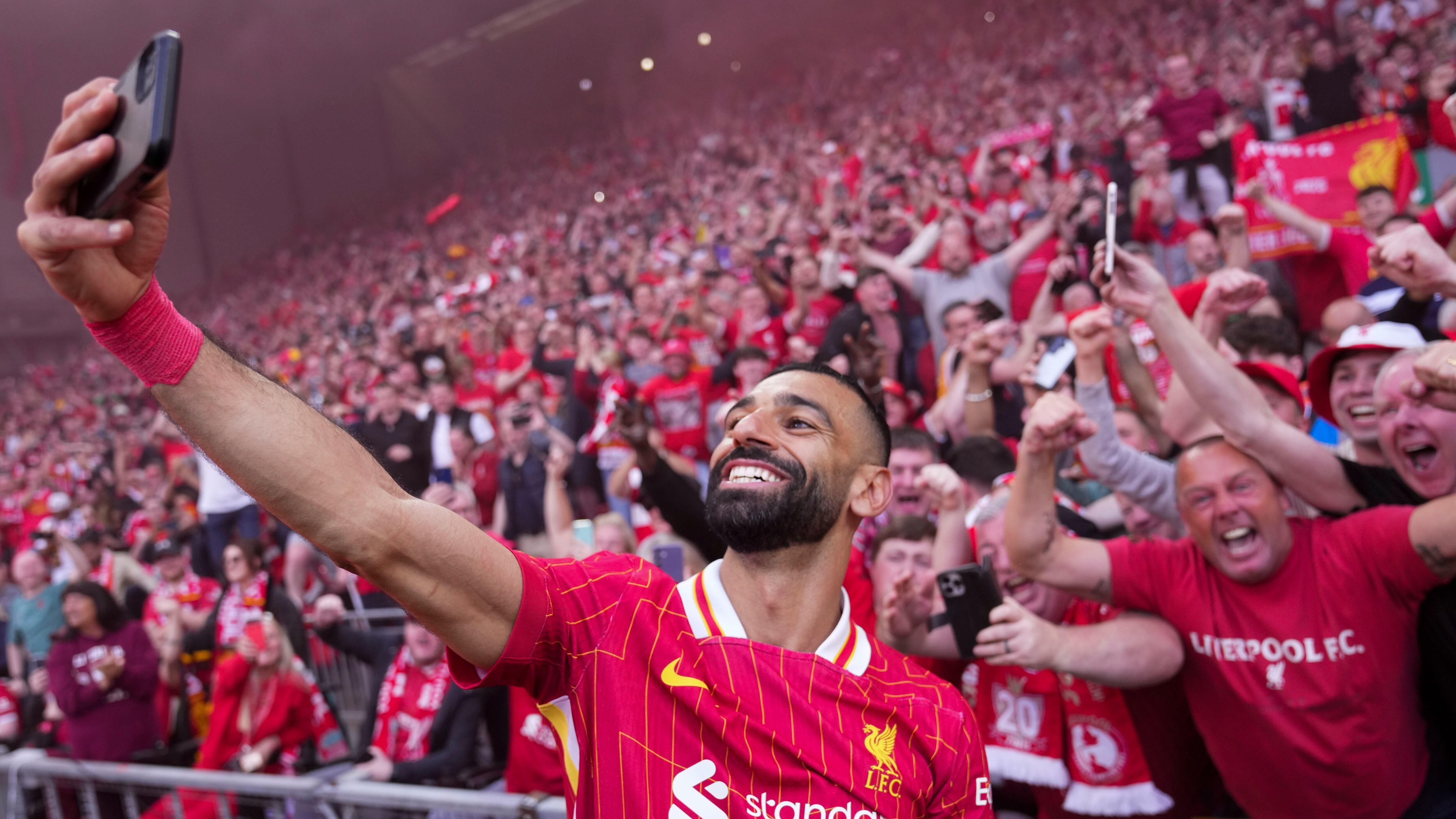 Liverpool's Mohamed Salah celebrates by taking a selfie after winning the English Premier League soccer match between Liverpool and Tottenham Hotspur and clinching the Premier League title at Anfield in Liverpool, England, Sunday, April 27, 2025.