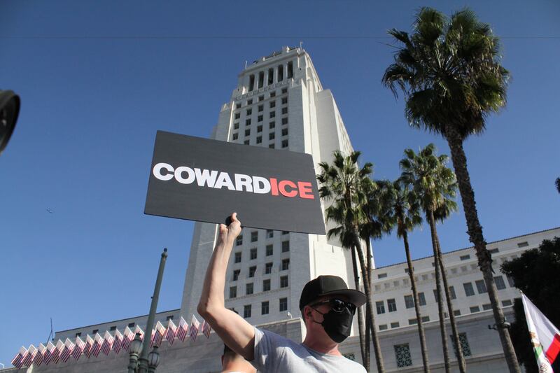 A man holds up a sign in front of City Hall during the national day of action.