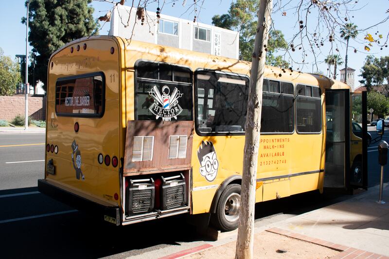"A photo of the side of a yellow school bus labeled 'HECTOR THE BARBER.'"