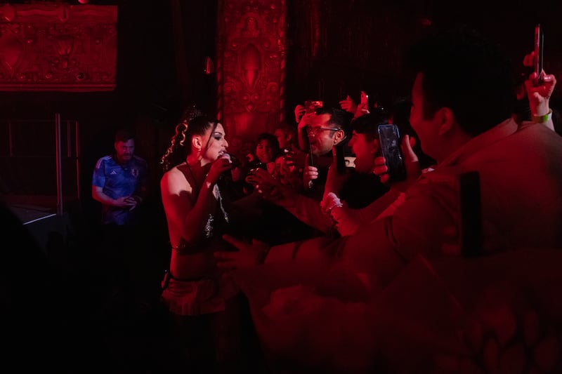 A photo of Arca serenading a fan in the audience.