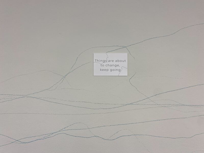 A photo of a note card that says "Things are about to change, keep going," displayed on a wall.