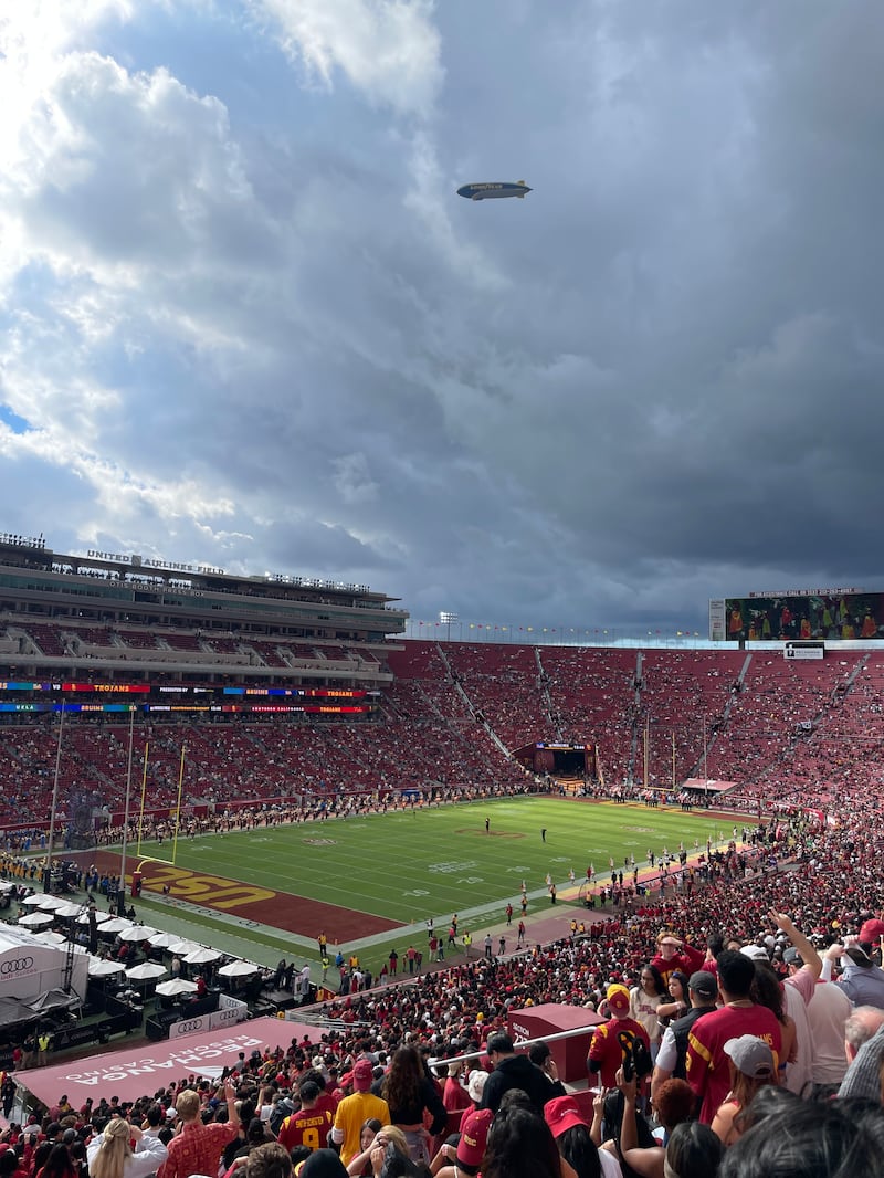 Photo of fans in red in the stands of the LA Memorial Coliseum